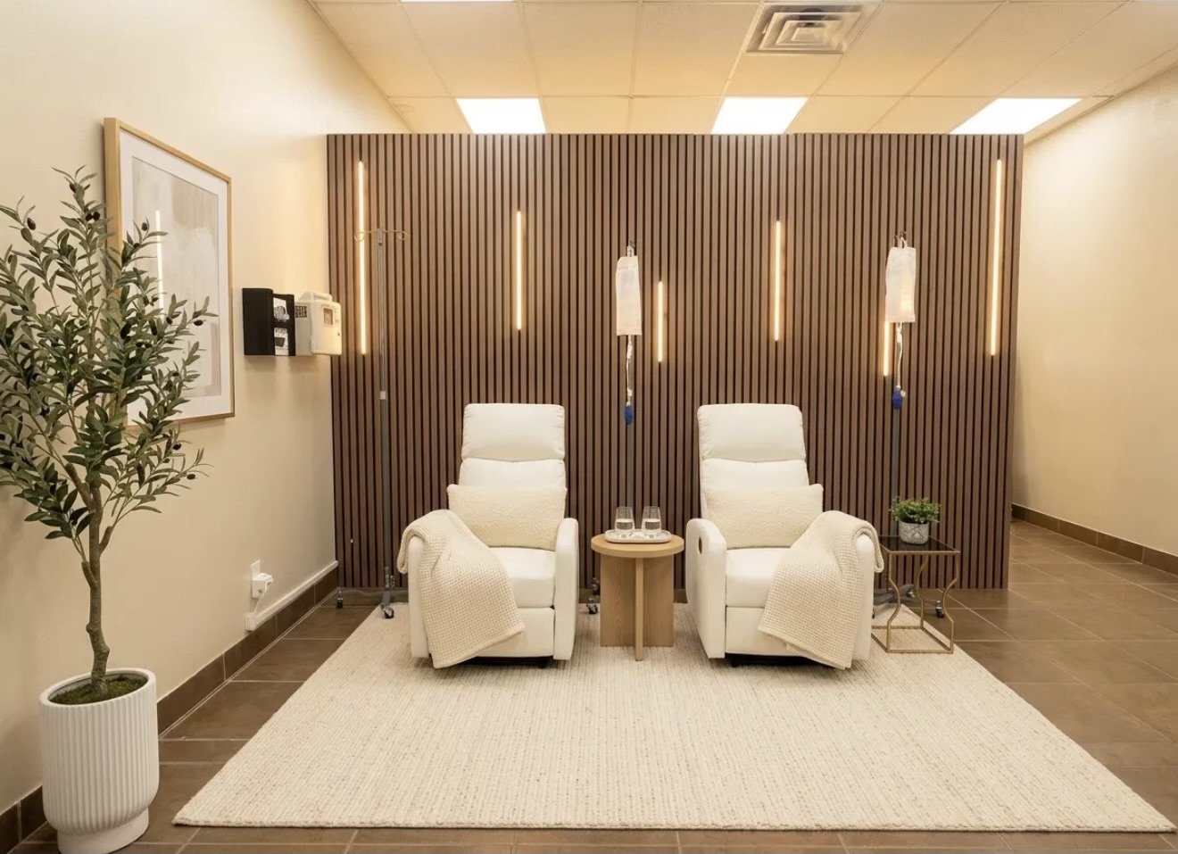 IV therapy lounge at Solas Health & Wellness in El Paso, TX — two recliners with IV stands in front of a wood slat wall