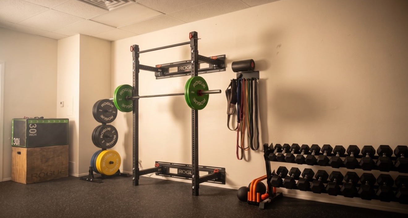 The strength training area at Solas Physical Therapy, 300 N Resler Dr Ste F, El Paso — Rogue rack, bumper plates, dumbbells and resistance bands